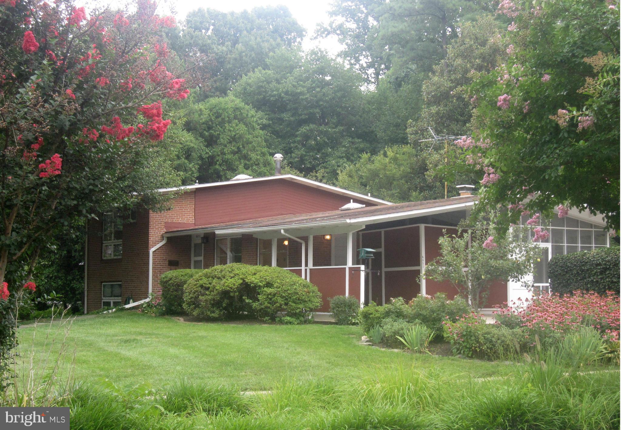 Street view showing carport beyond large lawn