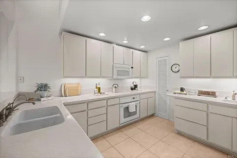 a kitchen with sink refrigerator and cabinets