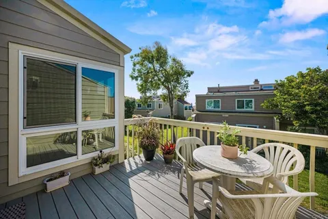 a balcony with wooden floor table and chairs