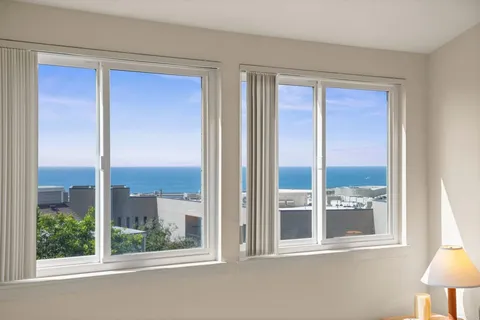 a view of a room that has a window and wooden floor