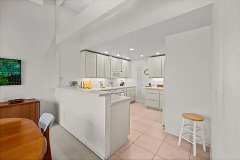 a kitchen with a refrigerator and white cabinets