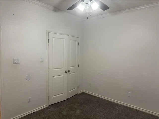 an empty room with a chandelier fan