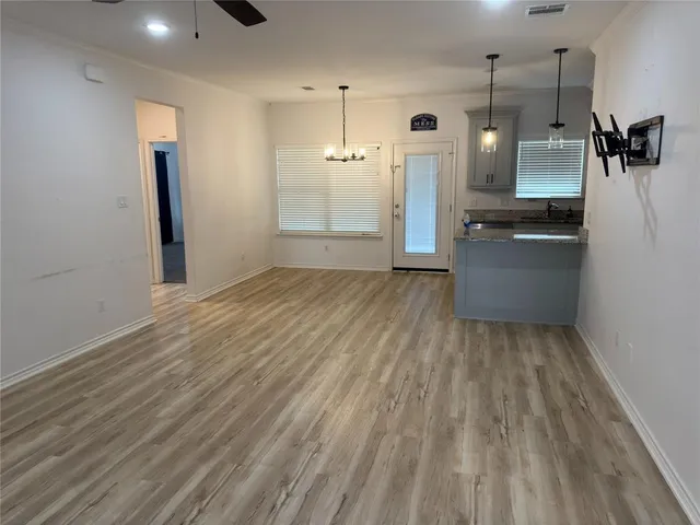 a view of a kitchen with a sink and dishwasher a refrigerator with wooden floor