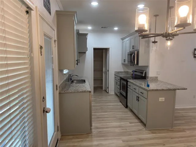 a kitchen with stainless steel appliances granite countertop a stove and a refrigerator