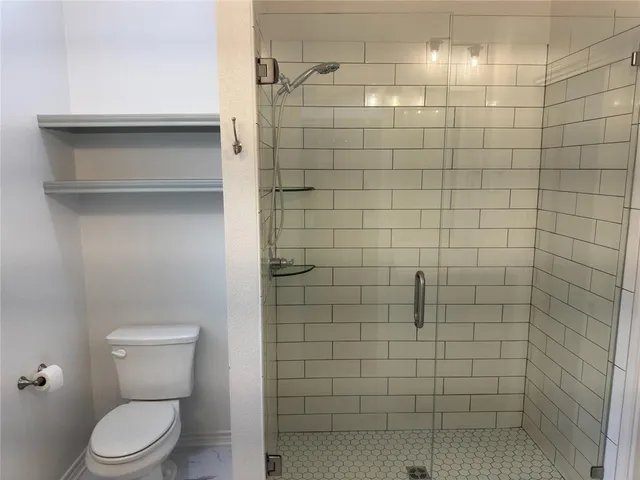 a bathroom with a toilet and a shower