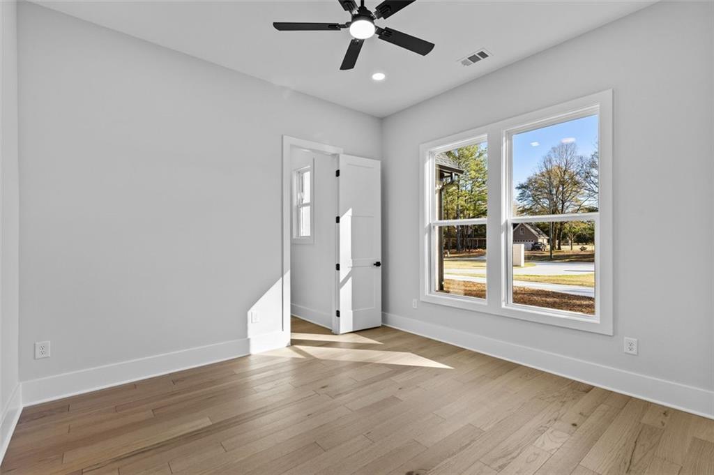 1198 Peters Cemetary Road Monroe, GA 30655 - Photo 43 of 64 a view of an empty room with a window and wooden floor