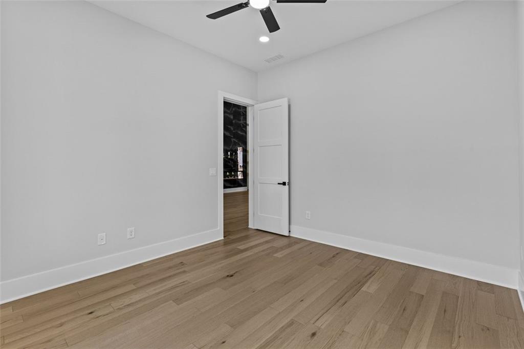 1198 Peters Cemetary Road Monroe, GA 30655 - Photo 44 of 64 an empty room with wooden floor ceiling fan and windows