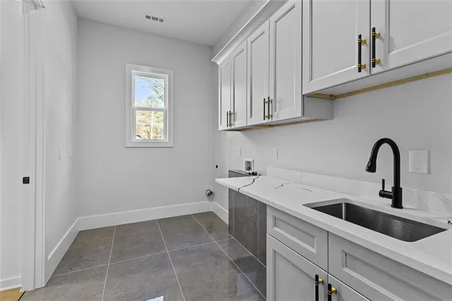 a view of an empty room with window and a kitchen