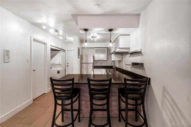 a kitchen with stainless steel appliances a dining table and chairs