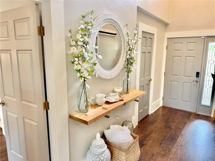 a living room with furniture large window and wooden floor