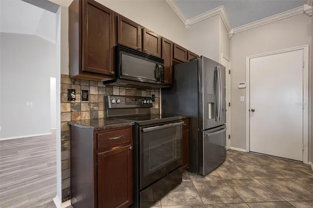 a kitchen with stainless steel appliances granite countertop a refrigerator stove and microwave