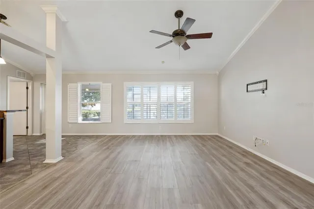 a view of empty room with wooden floor and window