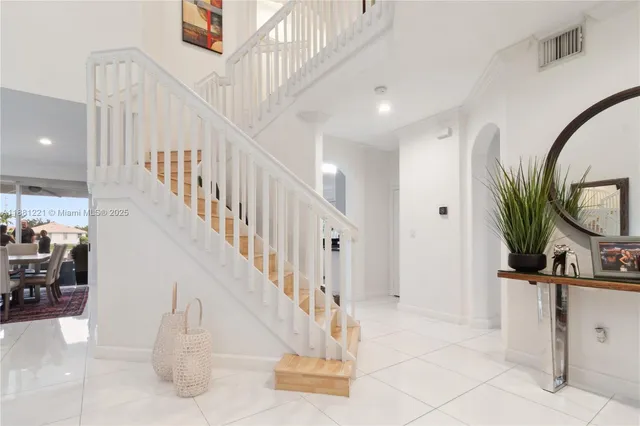 a living room with furniture flowerpot and a chandelier