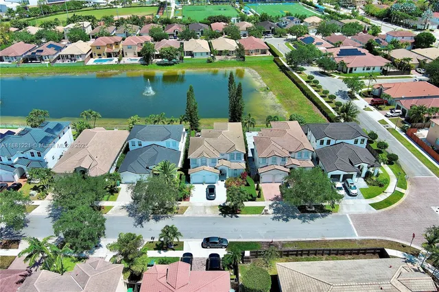 an aerial view of residential houses with outdoor space and lake view
