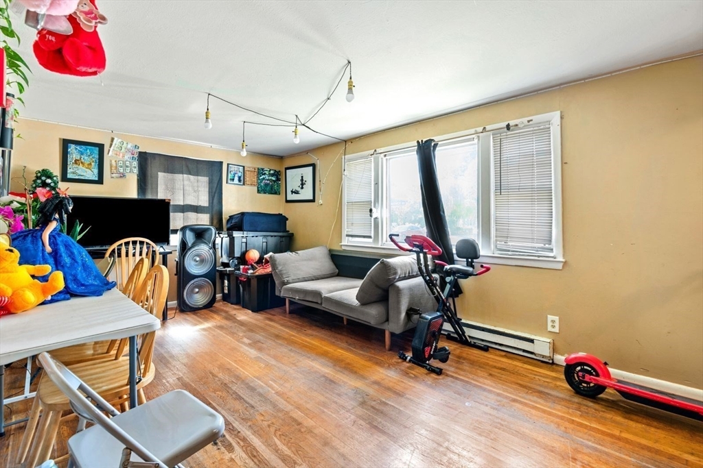 48 Hardwick Terrace Boston, MA 02135 - Photo 15 of 32 a living room with furniture gym equipment and a large window