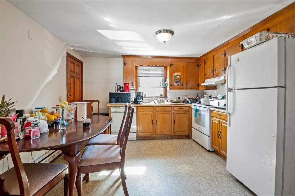 48 Hardwick Terrace Boston, MA 02135 - Photo 17 of 32 a kitchen with a refrigerator a stove a sink dishwasher with a dining table and chairs