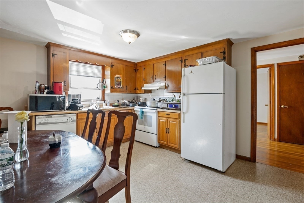 48 Hardwick Terrace Boston, MA 02135 - Photo 18 of 32 a kitchen with refrigerator a stove a sink and white cabinets with wooden floor