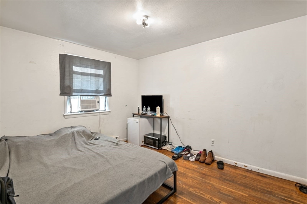 48 Hardwick Terrace Boston, MA 02135 - Photo 25 of 32 a bedroom with a bed and wooden floor