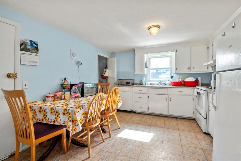 48 Hardwick Terrace Boston, MA 02135 - Photo 5 of 32 a kitchen with a dining table chairs and white cabinets