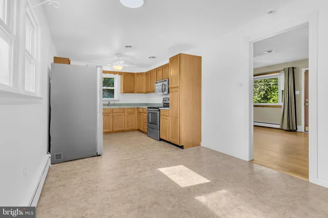 a view of a kitchen with refrigerator stove and wooden floor