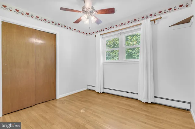 a view of a hallway with a chandelier fan and wooden floor