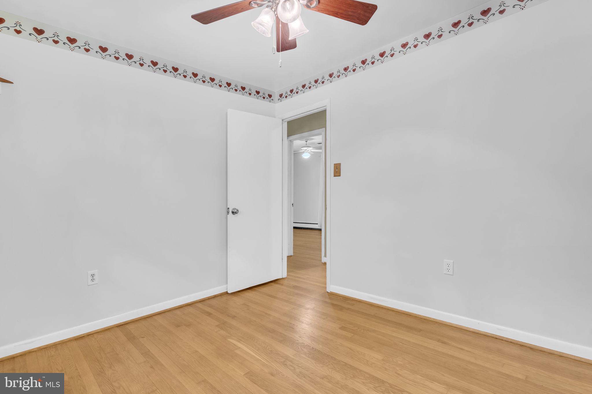16500 Baden Naylor Road Brandywine, MD 20613 - Photo 17 of 37 a view of a hallway with a chandelier fan and wooden floor
