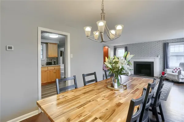 a view of a dining room with furniture a chandelier and wooden floor