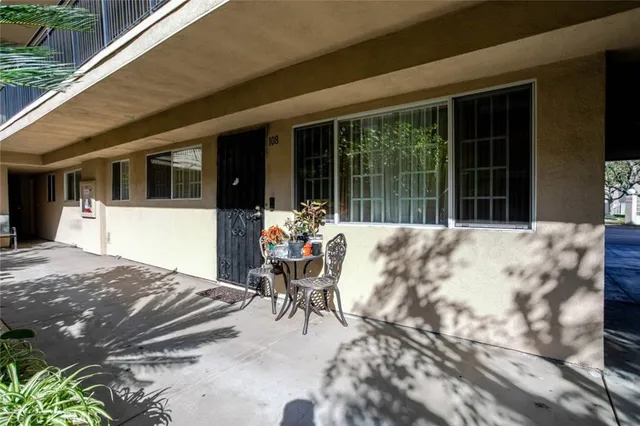 a view of a patio with table and chairs with wooden floor and fence
