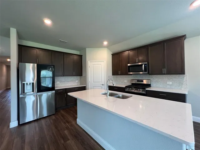 a kitchen with stainless steel appliances a microwave a sink and refrigerator
