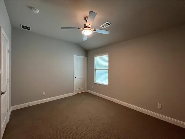 an empty room with a window and a fan