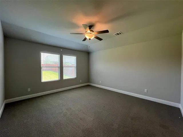an empty room with a window and a ceiling fan
