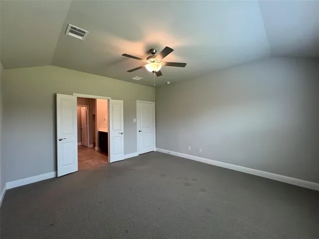 an empty room with closet and a chandelier fan
