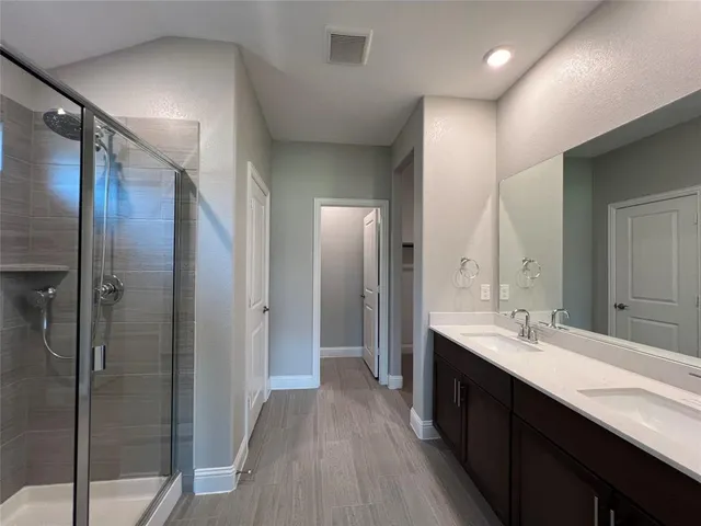 a bathroom with a double vanity sink mirror and shower