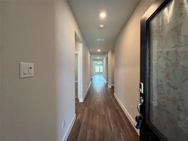 a view of a hallway with wooden floor and staircase