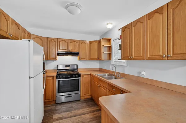 a kitchen with stainless steel appliances granite countertop a stove a sink dishwasher and a refrigerator