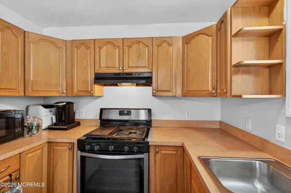 a kitchen with stainless steel appliances granite countertop a sink a stove and a microwave