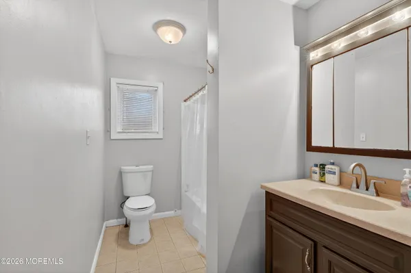 a bathroom with a granite countertop sink a toilet and a mirror