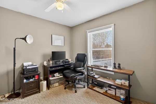 a view of a workspace with furniture and a window
