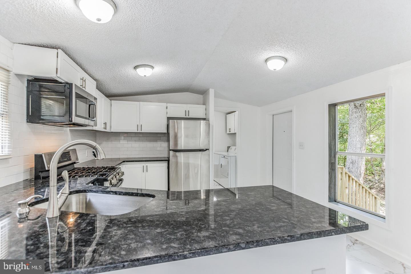 232 Jute Road Millville, NJ 08332 - Photo 12 of 30 a kitchen with stainless steel appliances granite countertop a sink stove and refrigerator