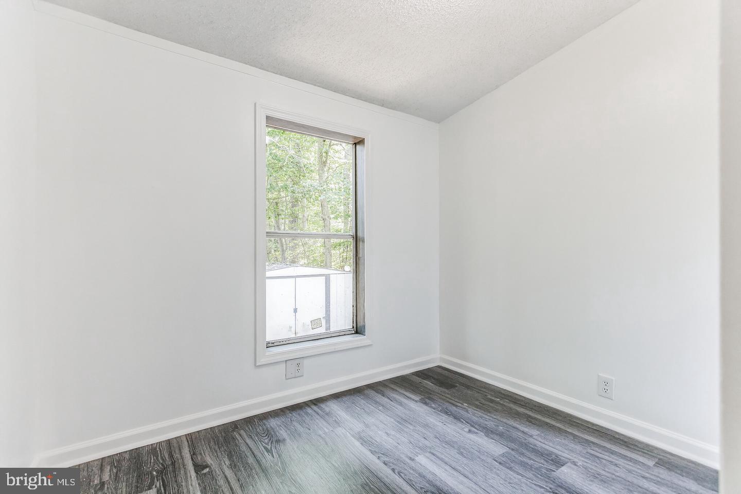 232 Jute Road Millville, NJ 08332 - Photo 22 of 30 an empty room with wooden floor and windows