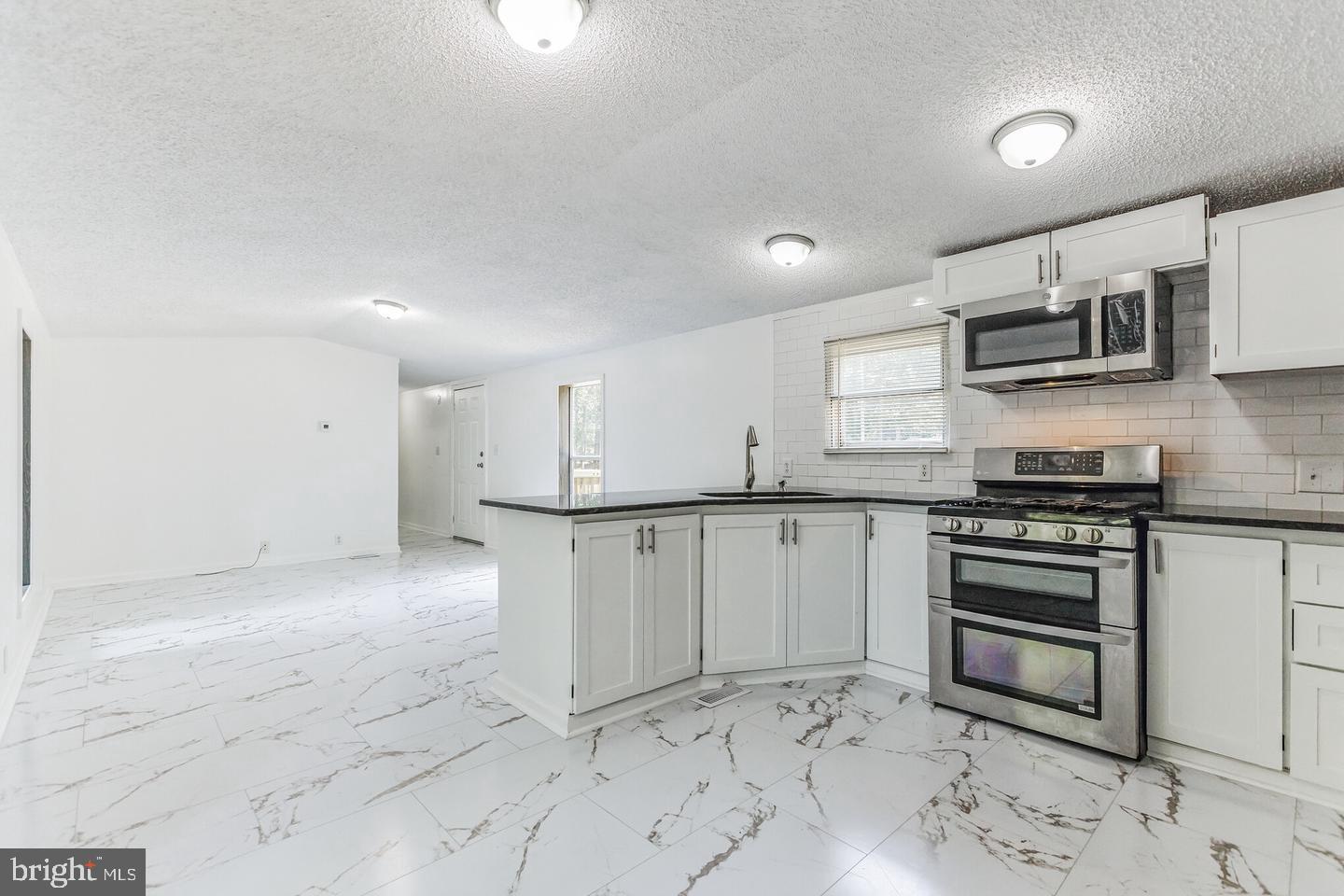 232 Jute Road Millville, NJ 08332 - Photo 9 of 30 a kitchen with stainless steel appliances granite countertop a stove top oven a sink and a granite counter tops