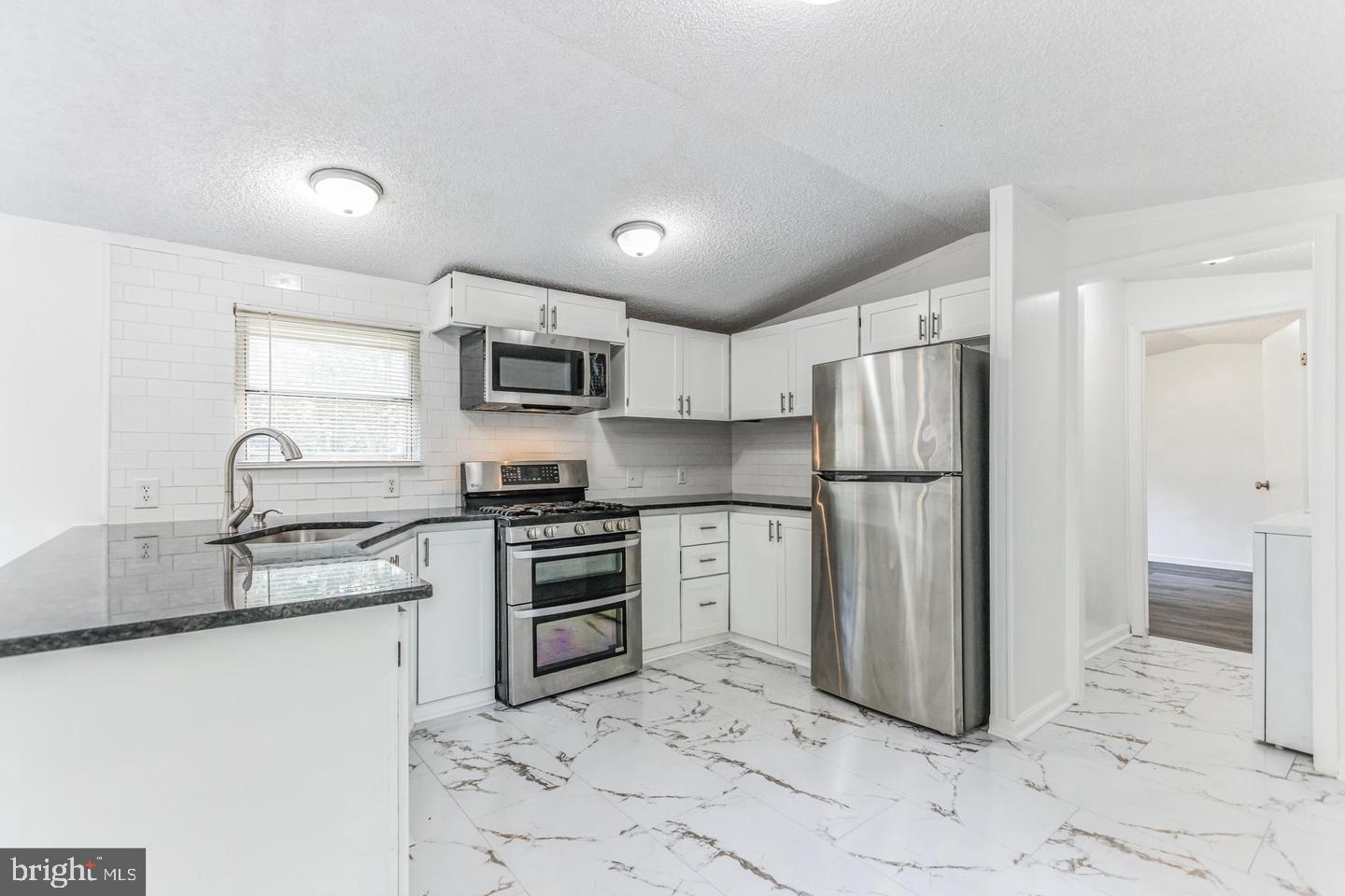 232 Jute Road Millville, NJ 08332 - Photo 10 of 30 a kitchen with granite countertop a refrigerator and a sink