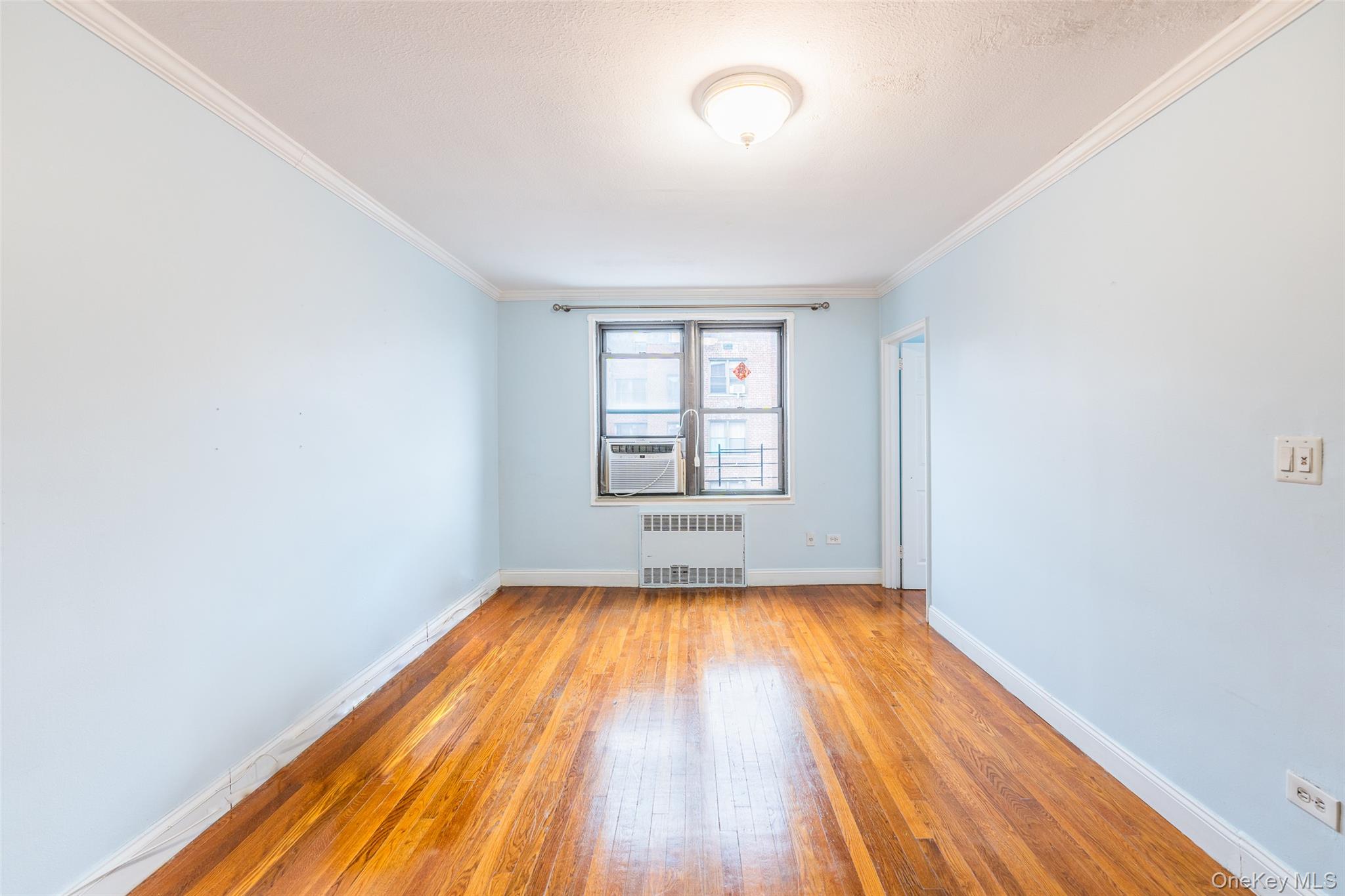 150-25 72nd Road, Unit 5K Queens, NY 11367 - Photo 14 of 21 wooden floor in a room next to a window