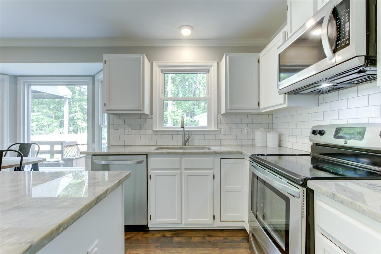 5516 Banwell Place Raleigh, NC 27613 - Photo 8 of 30 White Kitchen includes stainless steel appliances and back splash Kitchen