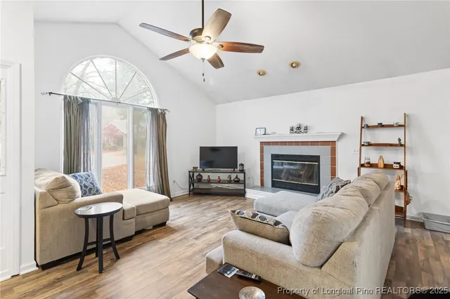 a living room with furniture a fireplace and a flat screen tv
