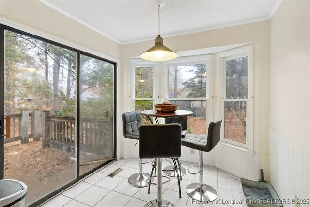 a dining room with furniture a chandelier and glass door