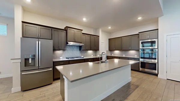 a large kitchen with stainless steel appliances and a refrigerator