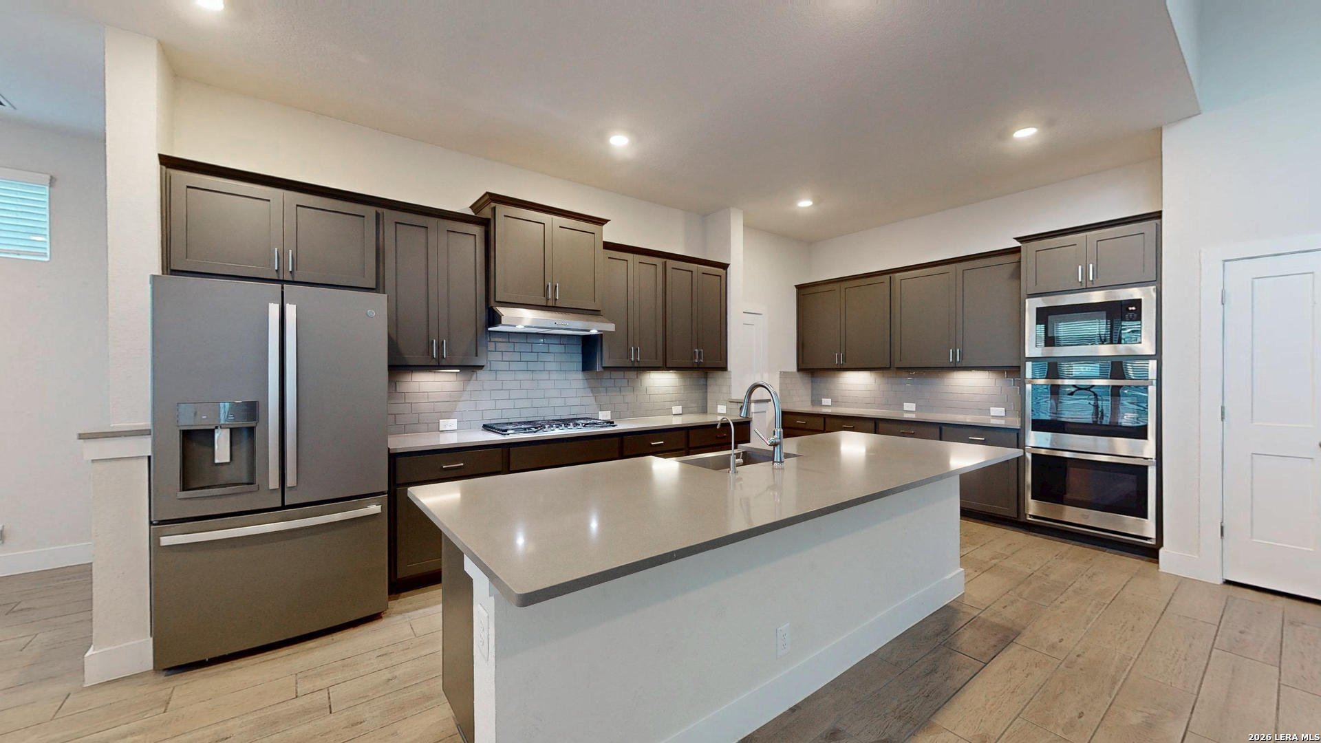 a large kitchen with stainless steel appliances and a refrigerator