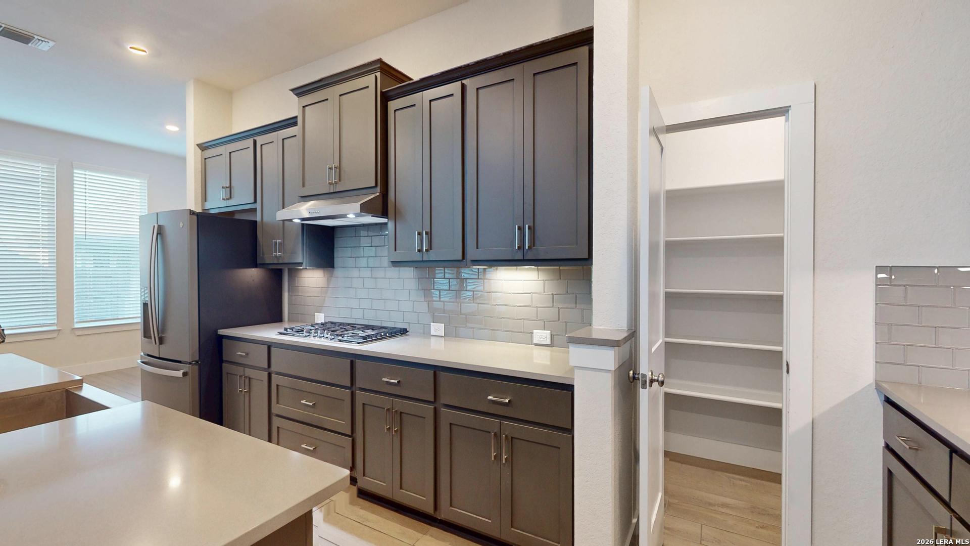 918 Rench New Braunfels, TX 78130 - Photo 8 of 41 a kitchen with stainless steel appliances granite countertop a refrigerator a sink dishwasher and wooden cabinets with wooden floor