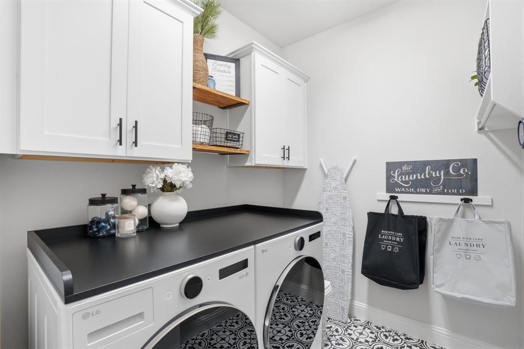 4202 Crown Run Road Midlothian, TX 76065 - Photo 27 of 34 Dedicated laundry space featuring white shaker-style cabinetry with matte black hardware, a black countertop, and a patterned floor